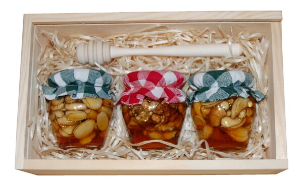 Set of nuts in honey in a box with a sliding lid