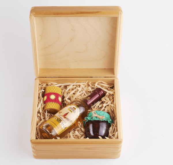 Set of dried fruits in honey with mead and a candle in a finely varnished box